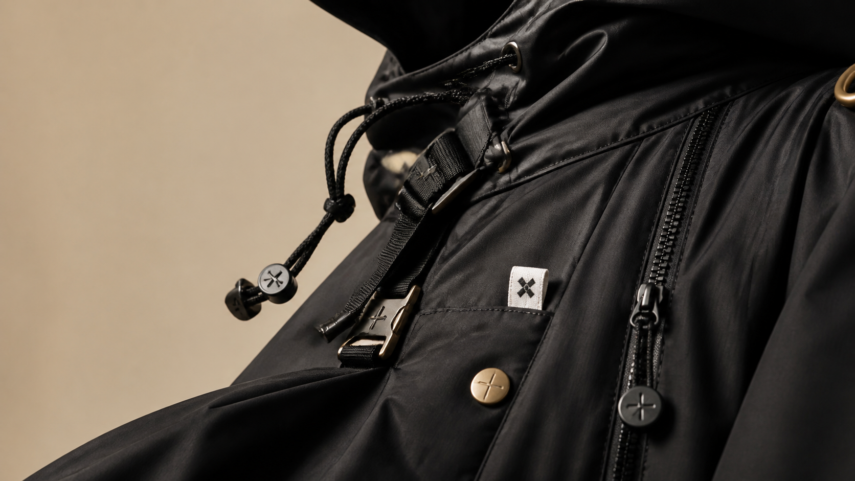 Premium black garment in motion with attached drawstrings, zipper pullers, woven label and metal hardware